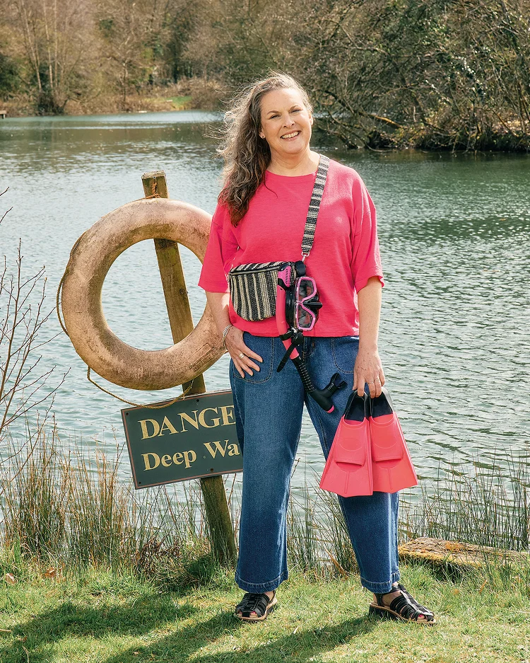 Frau in rosa T-Shirt und Jeans neben See