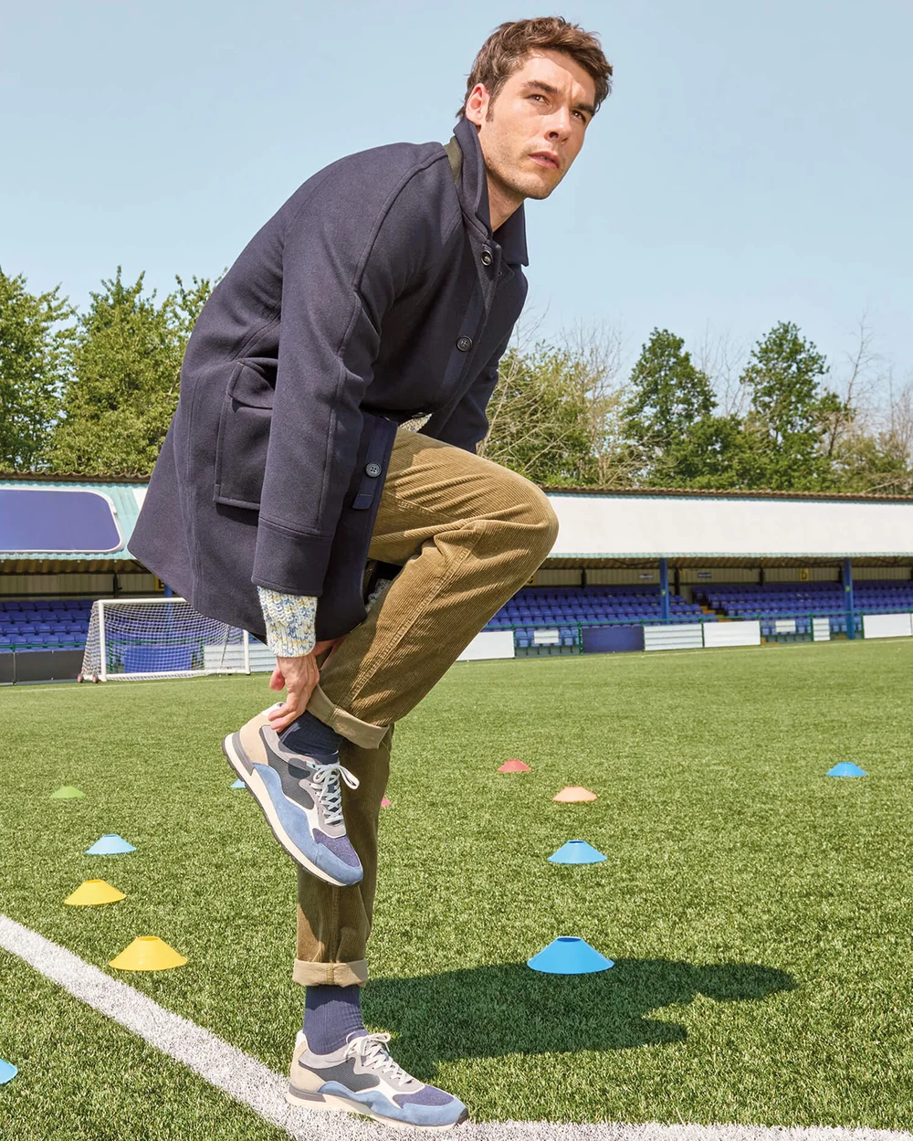 Mann im blauen Mantel, der sich nach unten beugt