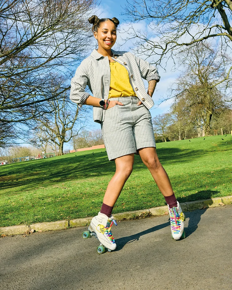 Rollschuhlaufende Frau in passenden Shorts und Jacke