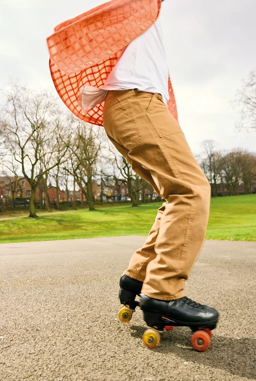 Mann in Hemd und Hose beim Rollschuhlaufen