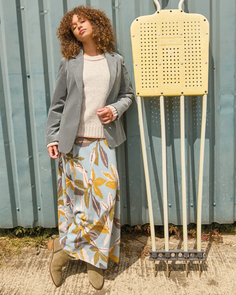 Rechts im Bild stylt sie das Outfit mit einem grünen Blazer.