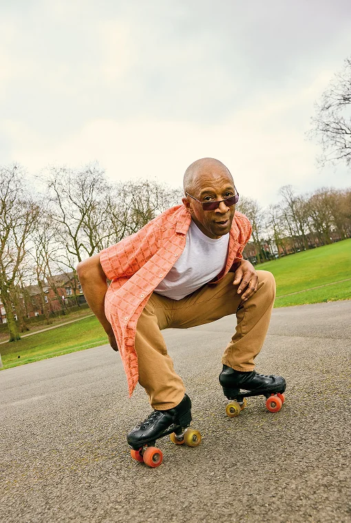 Mann in Hemd und Hose beim Rollschuhlaufen